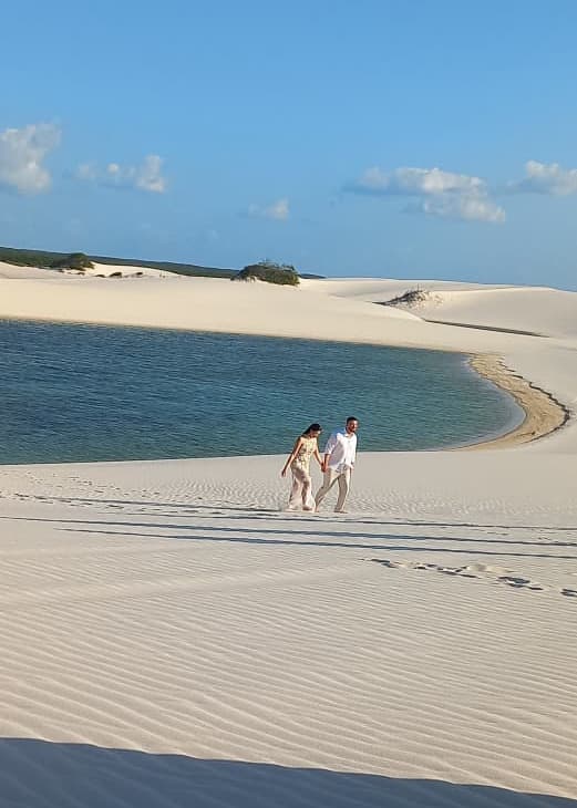 Casal caminhando nas dunas ao entardecer no Circuito Emendadas dos Lençóis Maranhenses