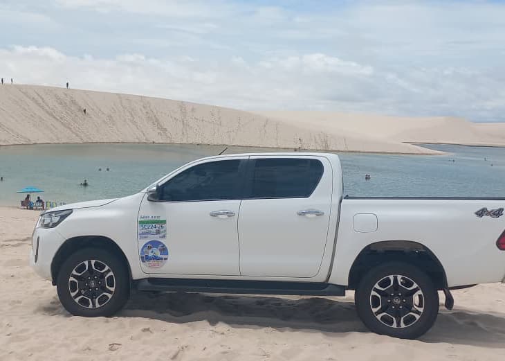 Hilux 4x4 branca da Renilton em frente a duna nos Lençóis Maranhenses