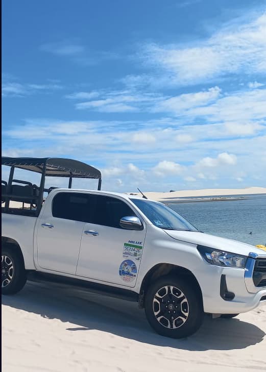 Hilux 4x4 branca da Renilton Turismo estacionada na beira da lagoa