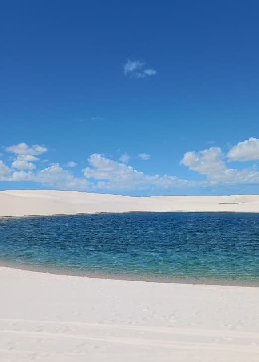 Lagoa plácida entre dunas brancas dos Lençóis Maranhenses