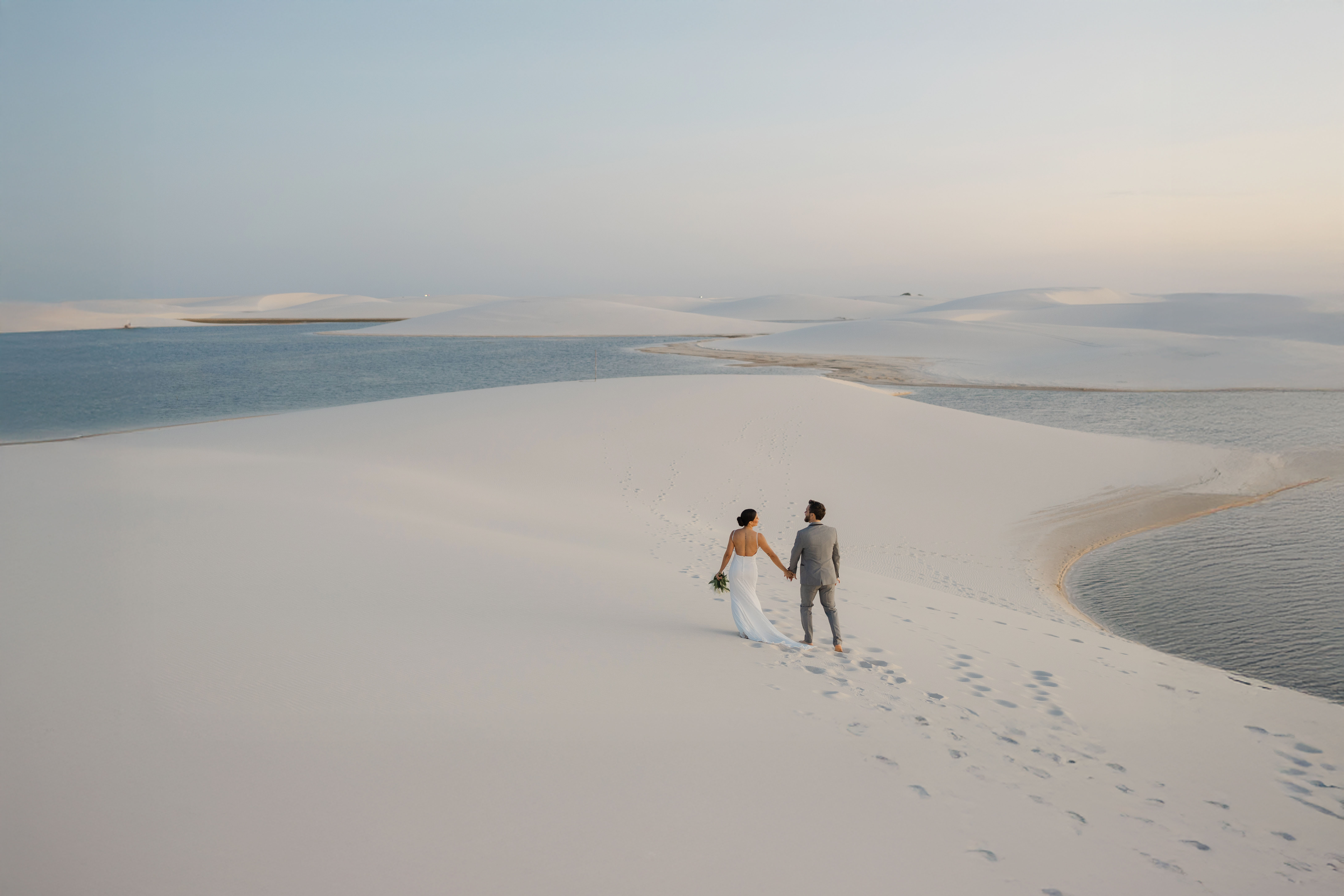 Noivos caminhando pelas dunas e lagoas dos Lençóis Maranhenses
